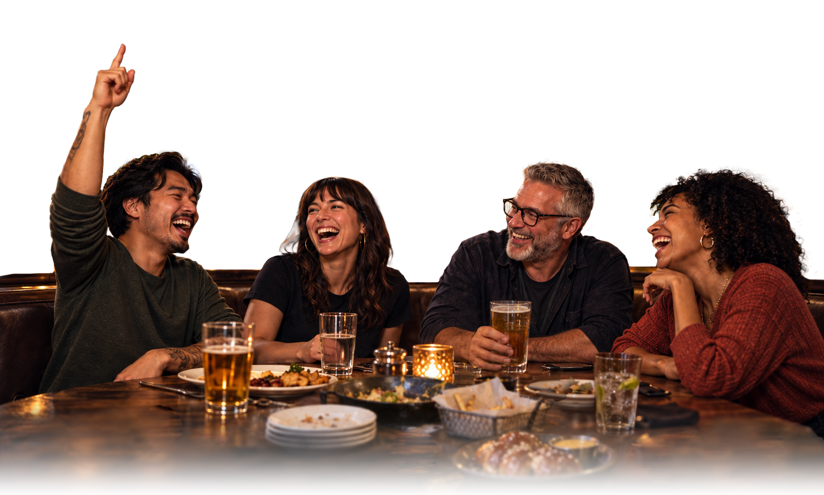 Friends laughing together over food at a warmly lit restaurant game night.